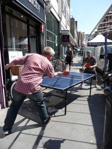 Two men playing table tennis in the street